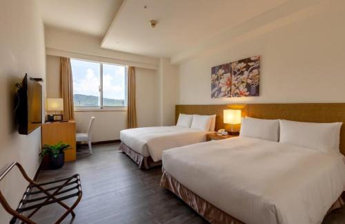 a hotel room with two beds and a television at Guide Education Culture Hotel Kaohsiung Museum of Fine Arts in Kaohsiung