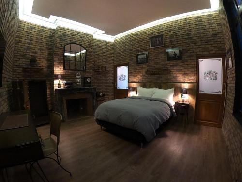 a bedroom with a bed and a brick wall at 35 SPEAKEASY - Ambiance PUB Anglais Centre Ville avec Parking in Reims