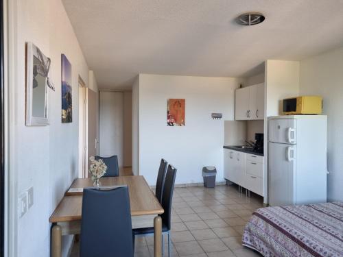 a kitchen and dining room with a table and a bed at Appartement dans la residence calme in Saint-Florent