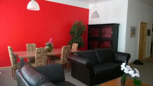 a living room with a red wall and a table and chairs at Home Sweet Home in Rīga