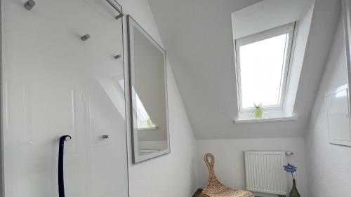 a white bathroom with a mirror and a window at Wohnung Maren in Sankt Peter-Ording