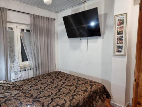 a bedroom with a bed and a flat screen tv on the wall at La Casa di Paulina in Cerveteri