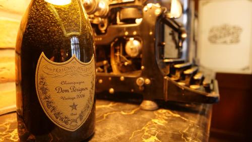 - une bouteille de vin assise à côté d'une machine à coudre dans l'établissement 35 SPEAKEASY - Ambiance PUB Anglais Centre Ville avec Parking, à Reims