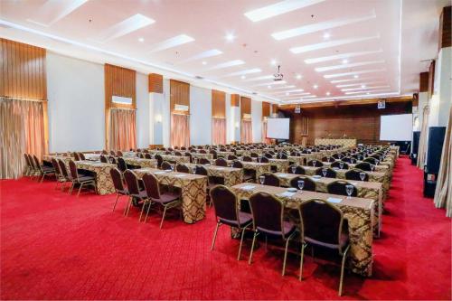 a large room with tables and chairs in it at Hotel Dafam Pekalongan in Pekalongan