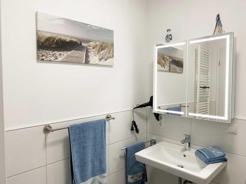 ein weißes Badezimmer mit einem Waschbecken und einem Spiegel in der Unterkunft Wiedbachtaljuwel in Roßbach