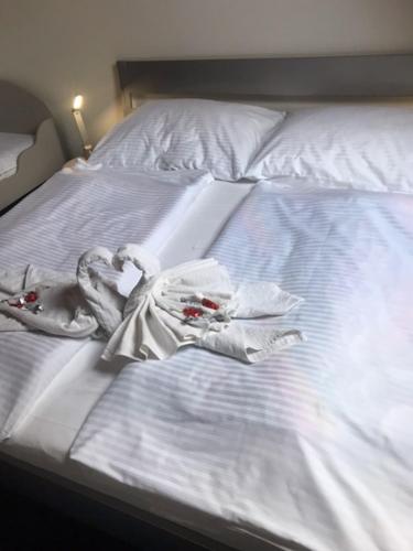 a white bed with some clothes on it at Penzión Zátoka in Liptovský Mikuláš