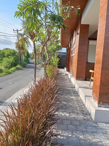 a sidewalk with plants next to a building at Mesari Villa in Keramas