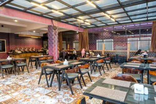 a restaurant with tables and chairs and people in the background at Premiere Hotel Tegal in Tegal