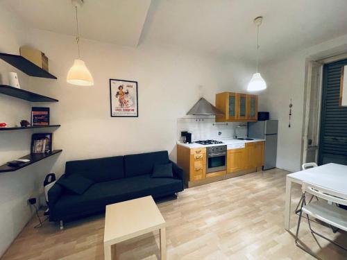 ein Wohnzimmer mit einem blauen Sofa und einer Küche in der Unterkunft Celso Otto in Florenz