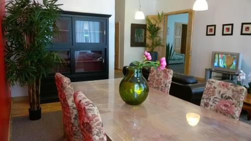 a dining room with a table with a vase on it at Home Sweet Home in Rīga