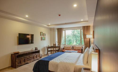 a bedroom with a large bed and a window at Roomy Signature Hotel, Islamabad in Islamabad