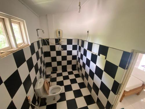 a bathroom with a black and white checkered wall at Sunflower Inn in Dambulla