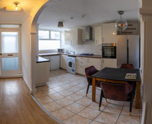 a kitchen with a table and a dining room at Regent's Park Sleeps 8 Pet Friendly & Garden in London