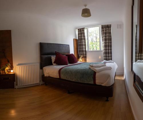 a bedroom with a large bed and a window at Regent's Park Sleeps 8 Pet Friendly & Garden in London