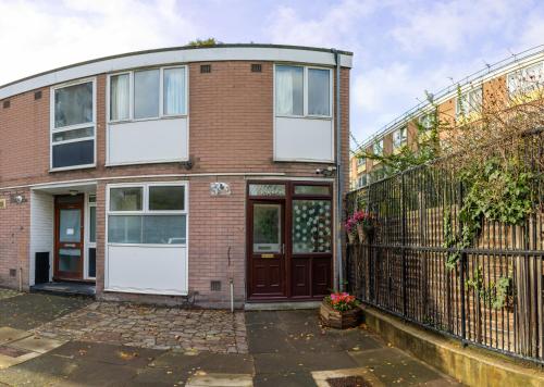 a brick house with a brown door and a fence at Regent's Park Sleeps 8 Pet Friendly & Garden in London
