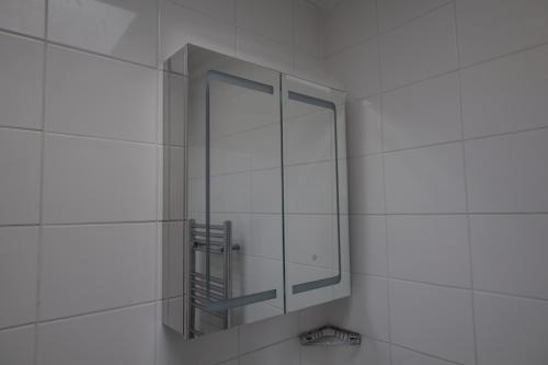 a mirror on the wall of a bathroom at Regent's Park Sleeps 8 Pet Friendly & Garden in London