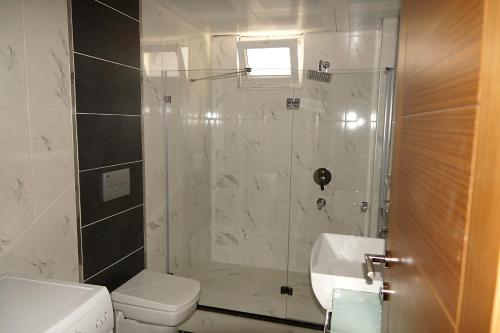 a bathroom with a shower and a toilet and a sink at Hayat Home Suite in Erzincan