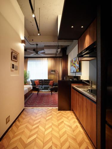 a kitchen and living room with a couch in the background at Acoustic GARAGE by Tranova in Tokyo