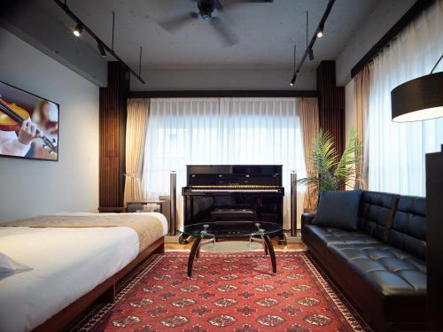 a bedroom with a bed and a couch and a piano at Acoustic GARAGE in Tokyo