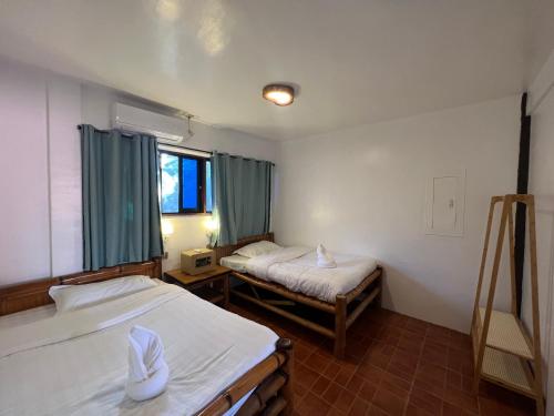 a room with two beds and a window at AoJing Diving Resort澳鲸潜水温泉店 in Dauin