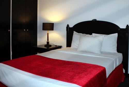 a bedroom with a large bed with a red blanket at Meliá Caracas in Caracas
