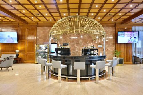 a large lobby with a bar with white chairs at Meliá Caracas in Caracas