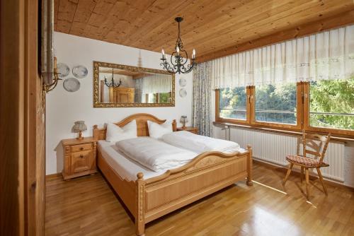 1 dormitorio con cama, espejo y silla en Alt Montafon Hotel Appartements, en Gaschurn