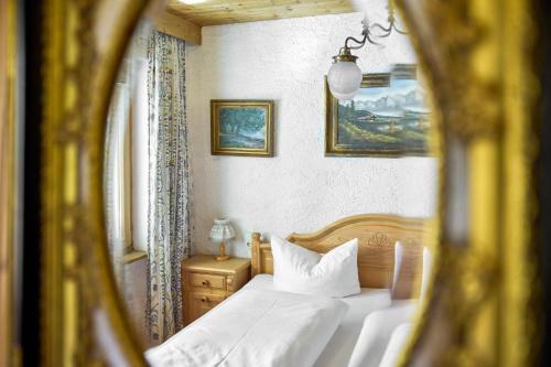 a bedroom with a bed with white sheets and a window at Alt Montafon Hotel Appartements by Pferd auf Wolke in Gaschurn