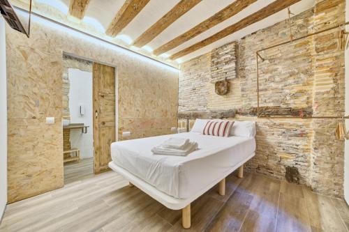 1 dormitorio con cama y pared de ladrillo en Casa Bidaiari by Clabao, en Pamplona