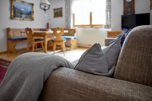 a living room with a couch with pillows on it at Alt Montafon Hotel Appartements by Pferd auf Wolke in Gaschurn
