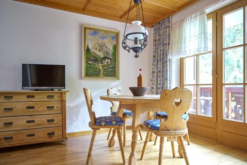 a dining room with a wooden table and chairs at Alt Montafon Hotel Appartements by Pferd auf Wolke in Gaschurn