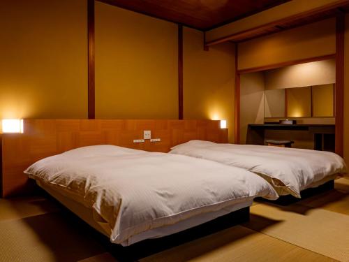 Ein Bett oder Betten in einem Zimmer der Unterkunft 越前あわら温泉　つるや