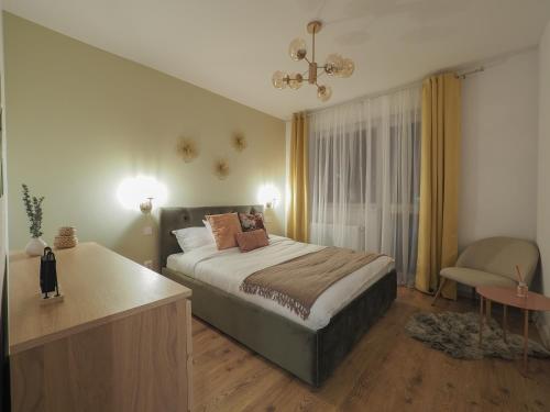 1 dormitorio con 1 cama con escritorio y silla en Cozy Nest Belvedere en Sibiu