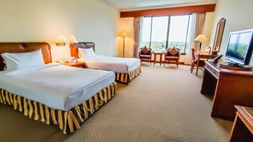 Ban Ru Sa Mi Laeにあるโรงแรม ซี.เอส. ปัตตานีのベッド2台、薄型テレビが備わるホテルルームです。