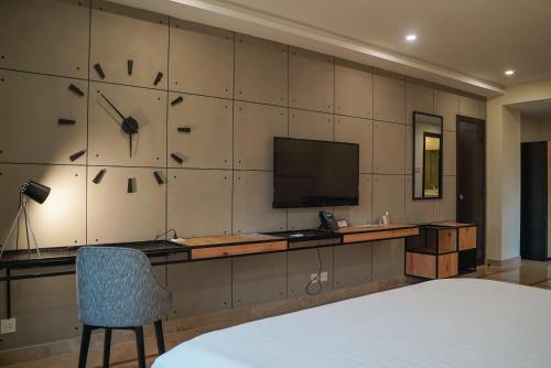 a room with a television and a desk with a chair at Roomy Signature Hotel, Islamabad in Islamabad