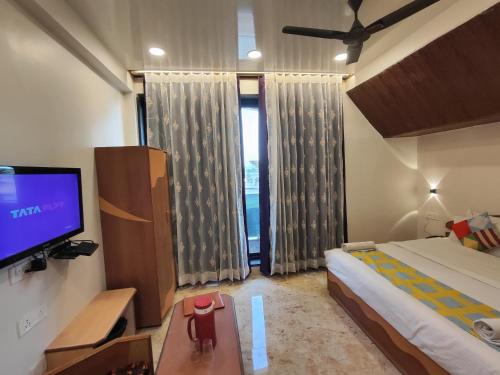 a bedroom with a bed and a flat screen tv at Hotel Always Welcome by SAH in Mount Ābu