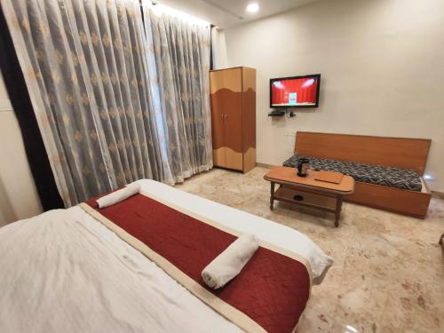 a bedroom with a bed and a tv in it at Hotel Always Welcome by SAH in Mount Ābu