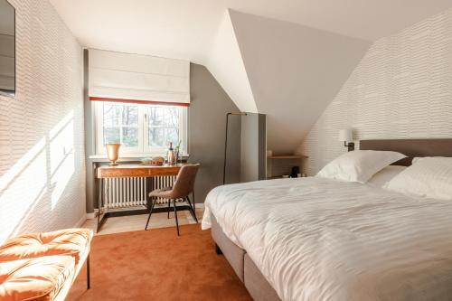 een slaapkamer met een bed en een bureau bij Villa Monceau in Ottignies