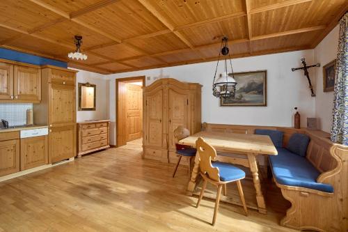 a kitchen with a wooden table and a blue couch at Alt Montafon Hotel Appartements by Pferd auf Wolke in Gaschurn