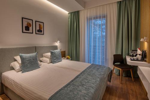 um quarto de hotel com uma cama e uma janela em Cardoner Hotel és Konferenciaközpont em Dobogoko