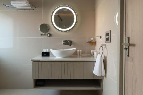 a bathroom with a sink and a mirror at Naturoville Resort in Doiwāla