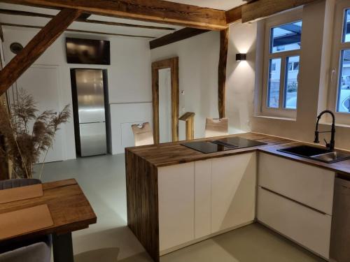una cucina con armadi bianchi e travi in legno di Casa Linda, luxuriöse Ferienwohnung im Grünen a Ober-Ramstadt