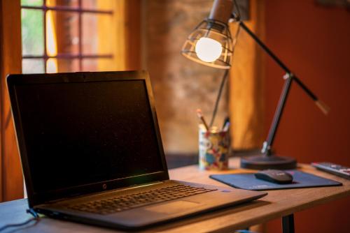 a laptop computer sitting on a desk with a lamp at The Pirates Lodge Milina - Chill-out in Strandnähe in Milína