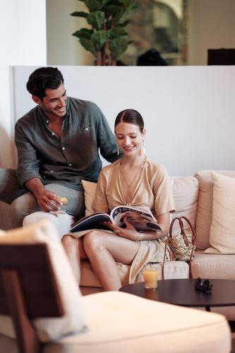 a man and a woman sitting on a couch at Ikaros Beach, Luxury Resort & Spa - Adults Only in Malia