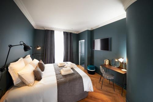 - une chambre avec un lit, un bureau et une télévision dans l'établissement Hotel Victoria, à Valence
