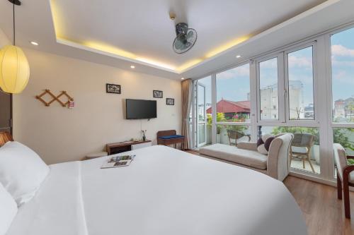 sypialnia z białym łóżkiem i dużym oknem w obiekcie Golden Legend Diamond Hotel w mieście Hanoi