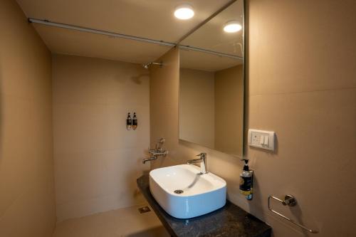 卡蘭古特的住宿－Sunshine Resort Calangute Goa，一间带水槽和镜子的浴室