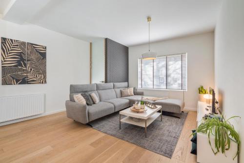 uma sala de estar com um sofá e uma mesa em Sersea - spacious holiday house in Ostend with garage em Oostende