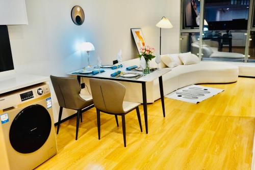 a living room with a table and chairs and a couch at Kunming Dianchi Mideel International Apartment - South Asian Style Fuhai Metro in Kunming