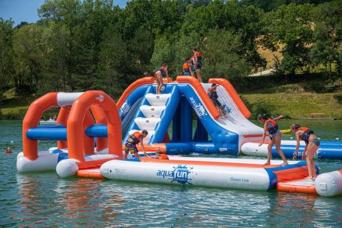 Bretagne-dʼArmagnacCamping les Lacs d'Armagnac的一群人,在水中充气水滑梯上